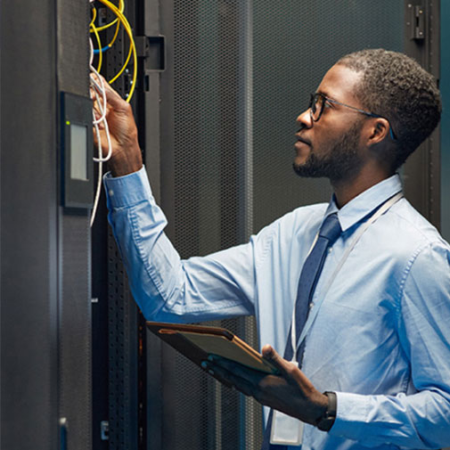 Technician inspecting network cables in a server room